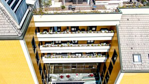 Un edificio de varios pisos con balcones, cada uno adornado con macetas.