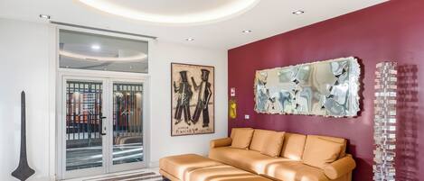 A modern living room with a sofa, abstract art, and a unique sculpture.