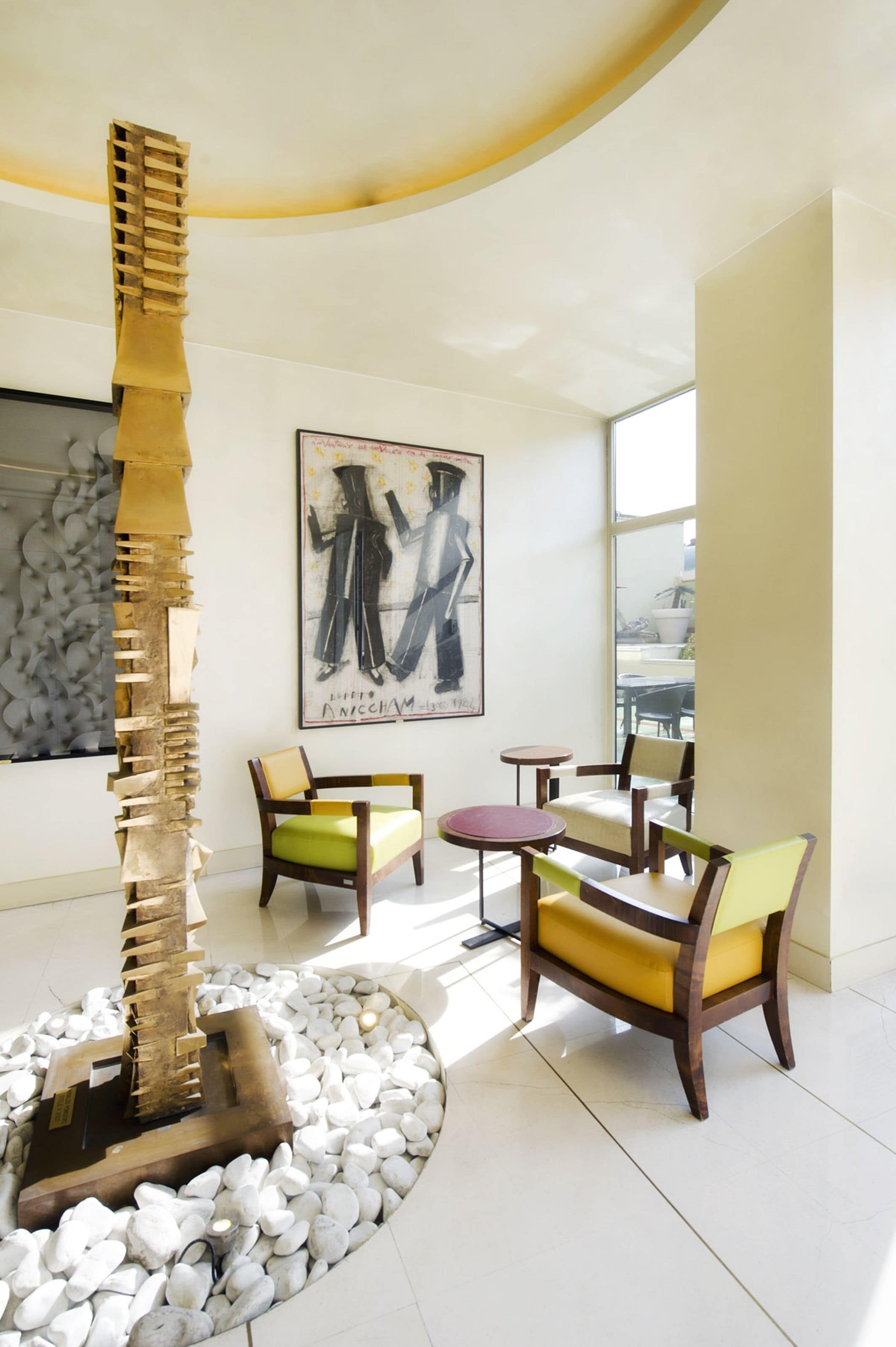 A modern interior with a unique sculpture, comfortable seating, and a large window offering natural light.