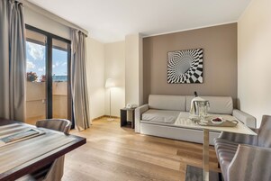 Een moderne woonkamer met een bank, een eettafel en uitzicht op de omgeving.