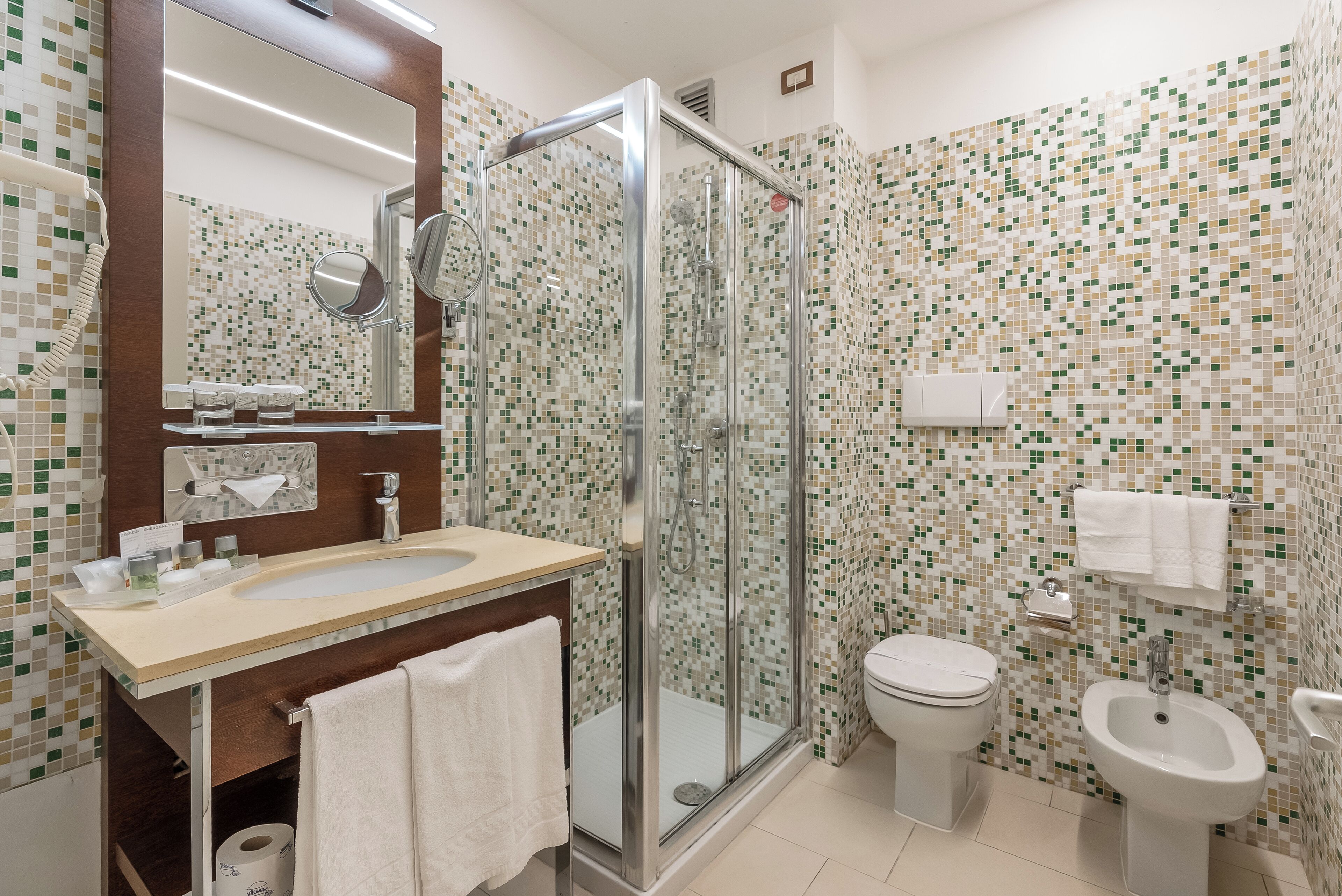 Ein modernes Badezimmer mit Duschkabine aus Glas, Waschbecken, Toilette und Bidet.