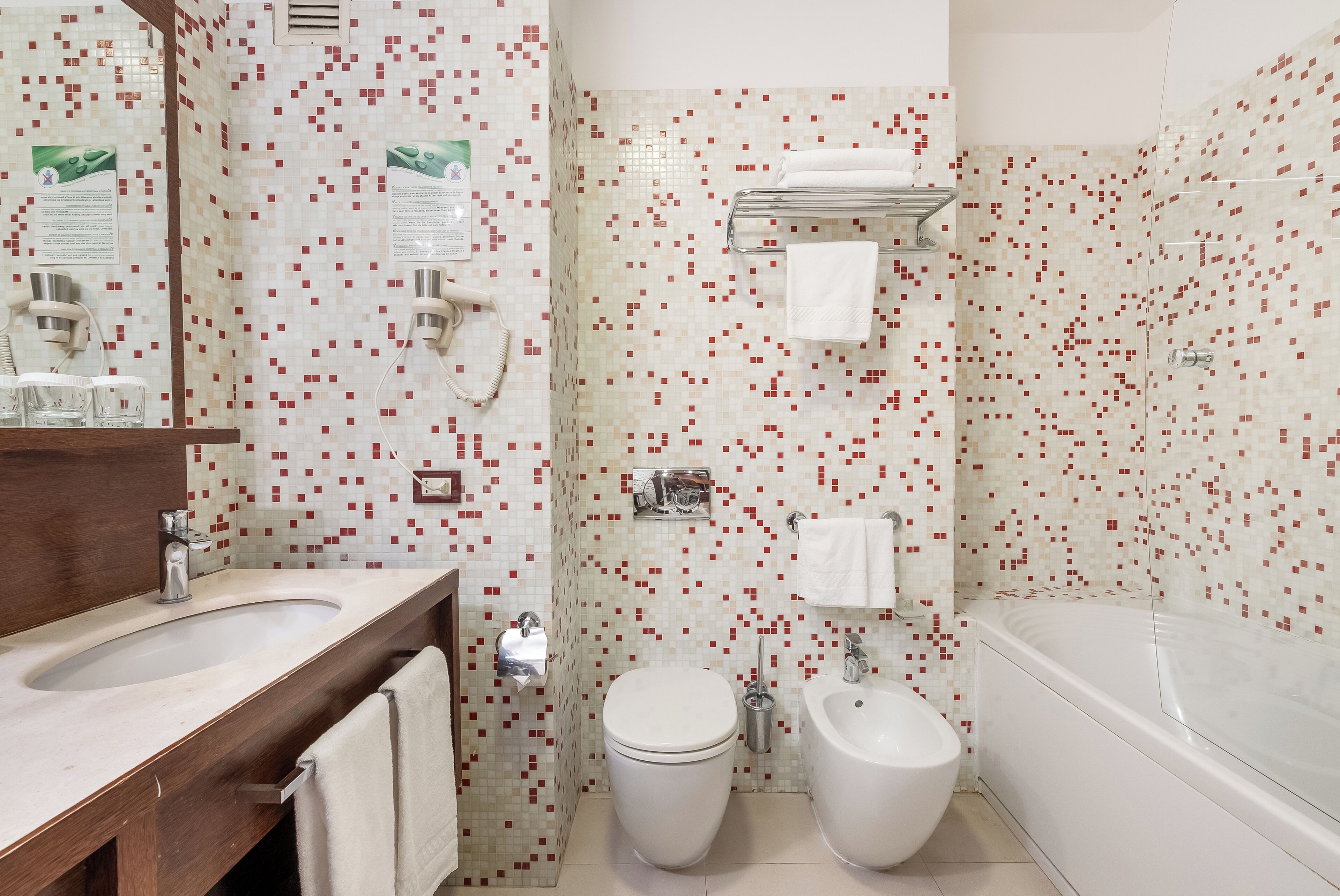 Un baño moderno con un lavabo grande, inodoro, bidé y bañera.