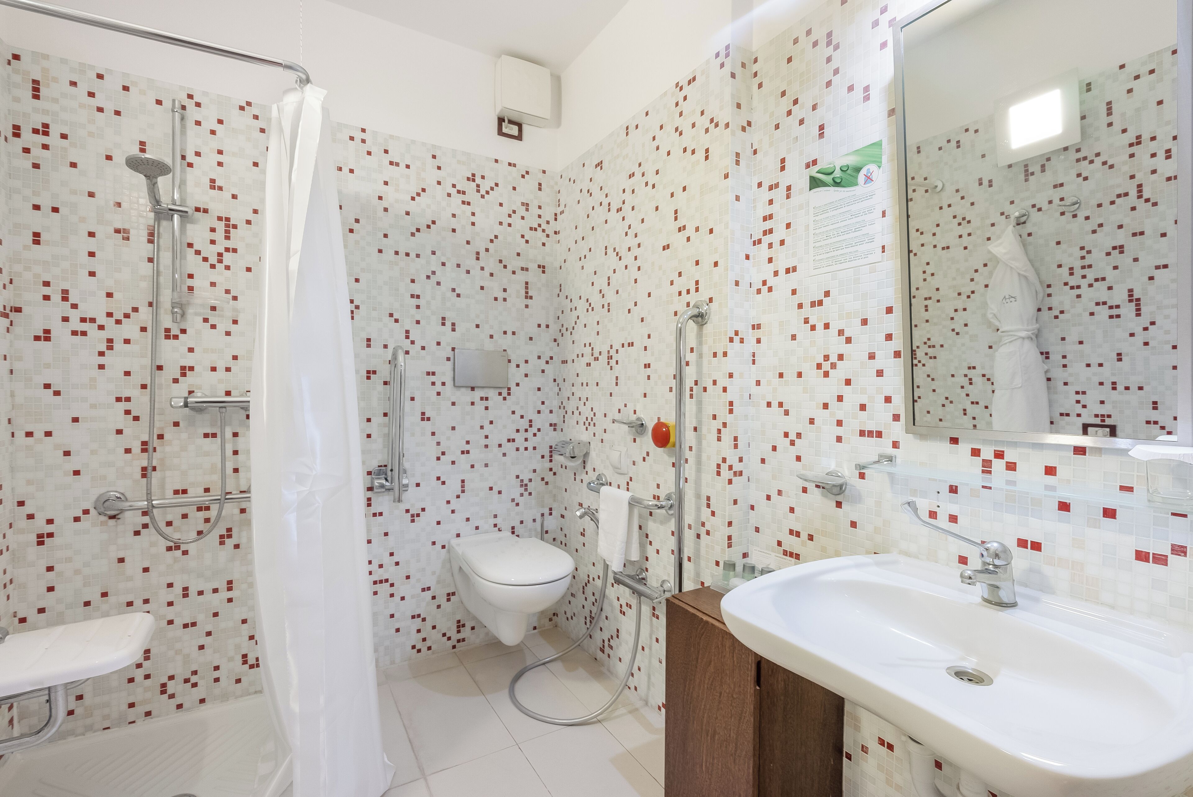 Un bagno con doccia, WC e lavandino.