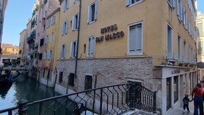 Un edificio con un letrero que dice "HOTEL SAN MARCO" y un restaurante llamado "ALBERGO" en la planta baja.