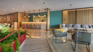 A modern living area with a bar, seating, and a staircase. - Occidental Vigo (Vigo)