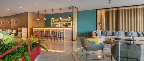 Un área de estar moderna con bar, asientos y una escalera.