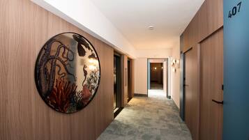 A hallway with wooden walls, a circular wall decoration, and a carpeted floor.