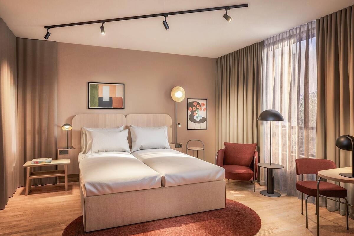 Une chambre d’hôtel moderne équipée d’un grand lit, d’un bureau, d’une chaise et d’une table à manger.