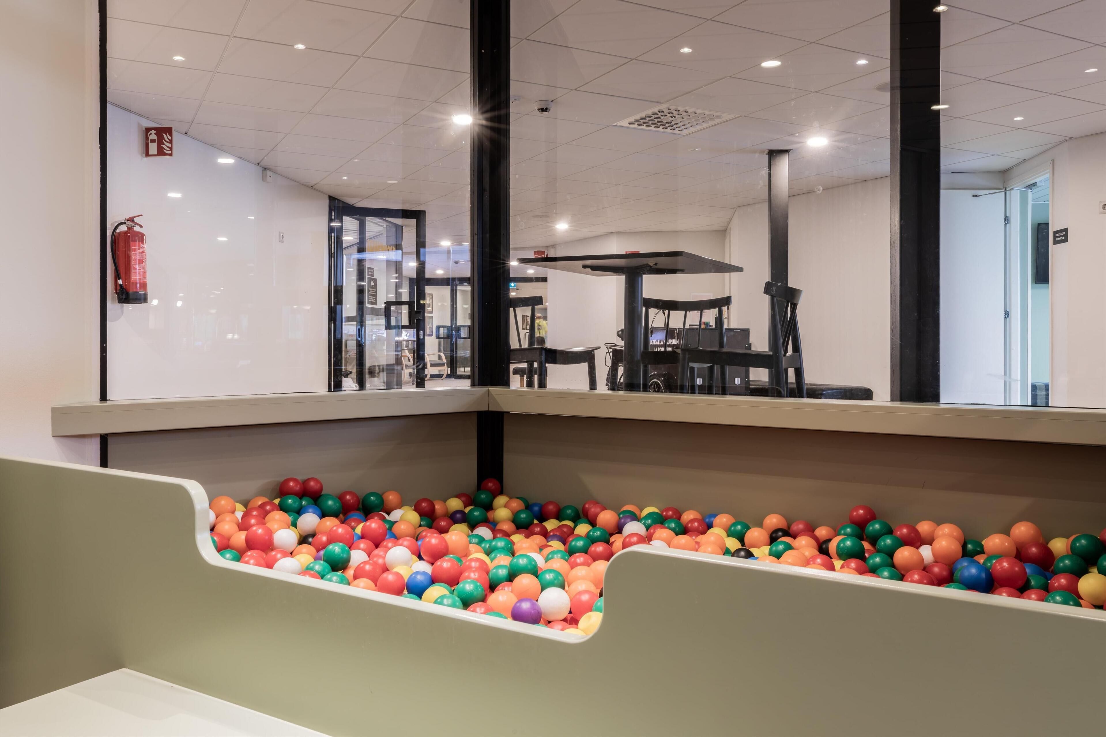 A children's play area with a ball pit and seating area.