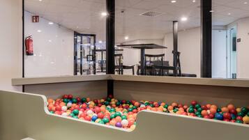 A children's play area with a ball pit and seating area.
