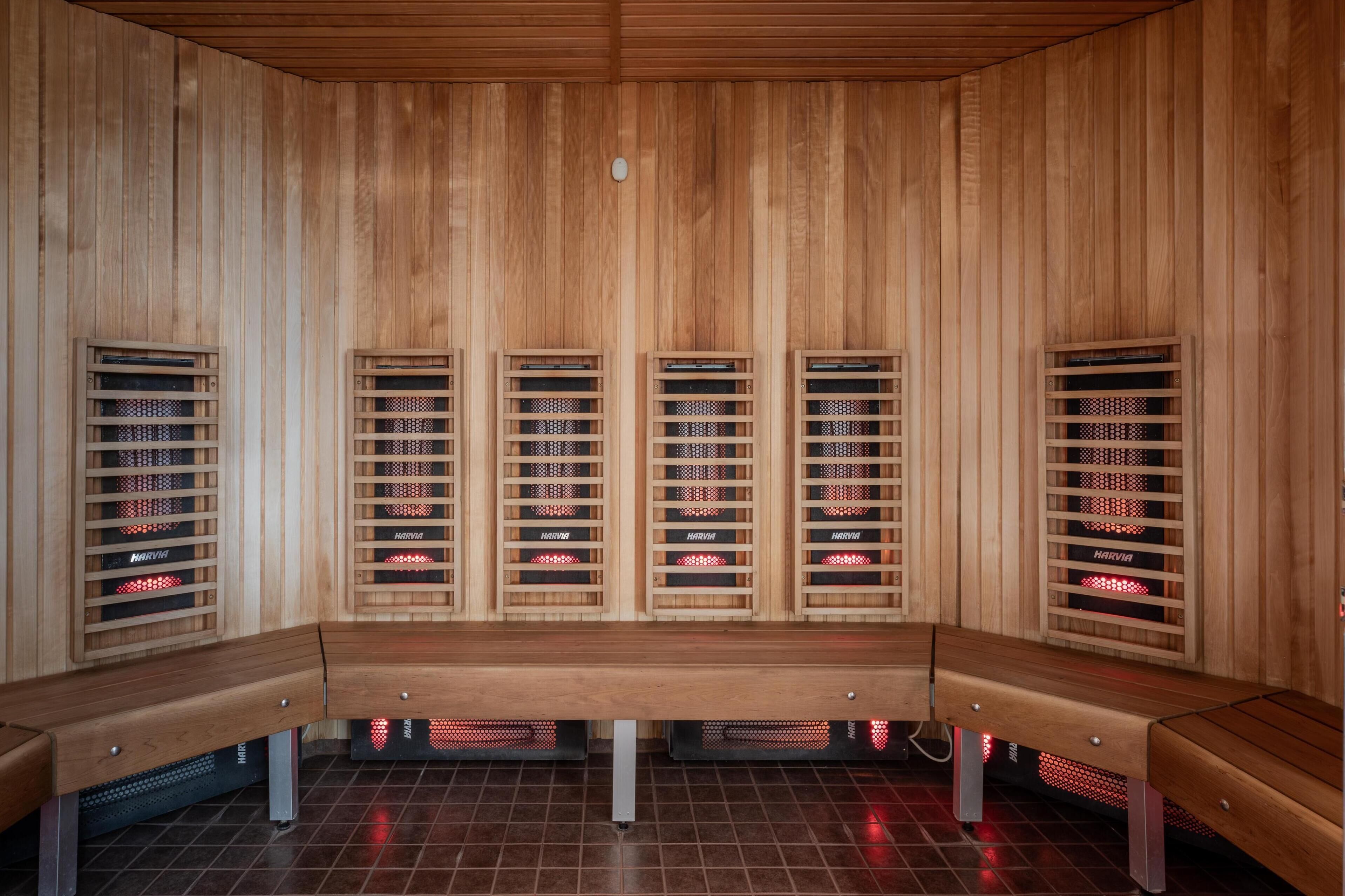 A sauna with wooden benches and multiple benches with heating elements.