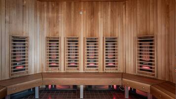 A sauna with wooden benches and multiple benches with heating elements.