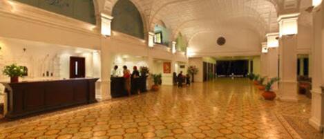 A spacious lobby with a patterned floor and a high arched ceiling.