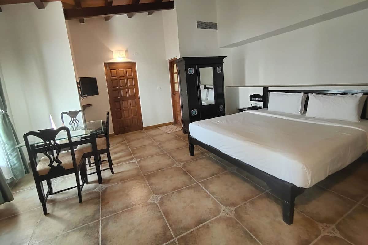 A bedroom with a bed, a desk, and a chair.