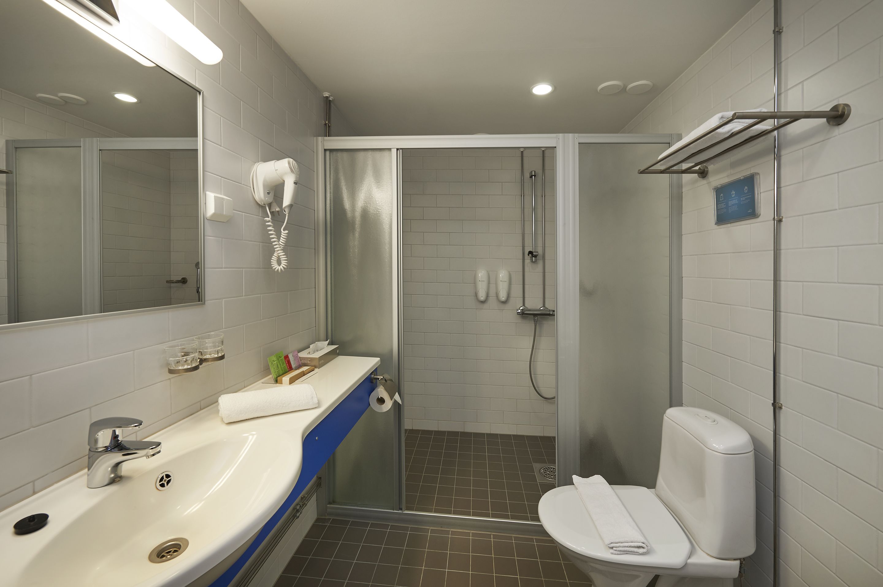 Ein modernes Badezimmer mit Waschbecken, Toilette und Dusche.