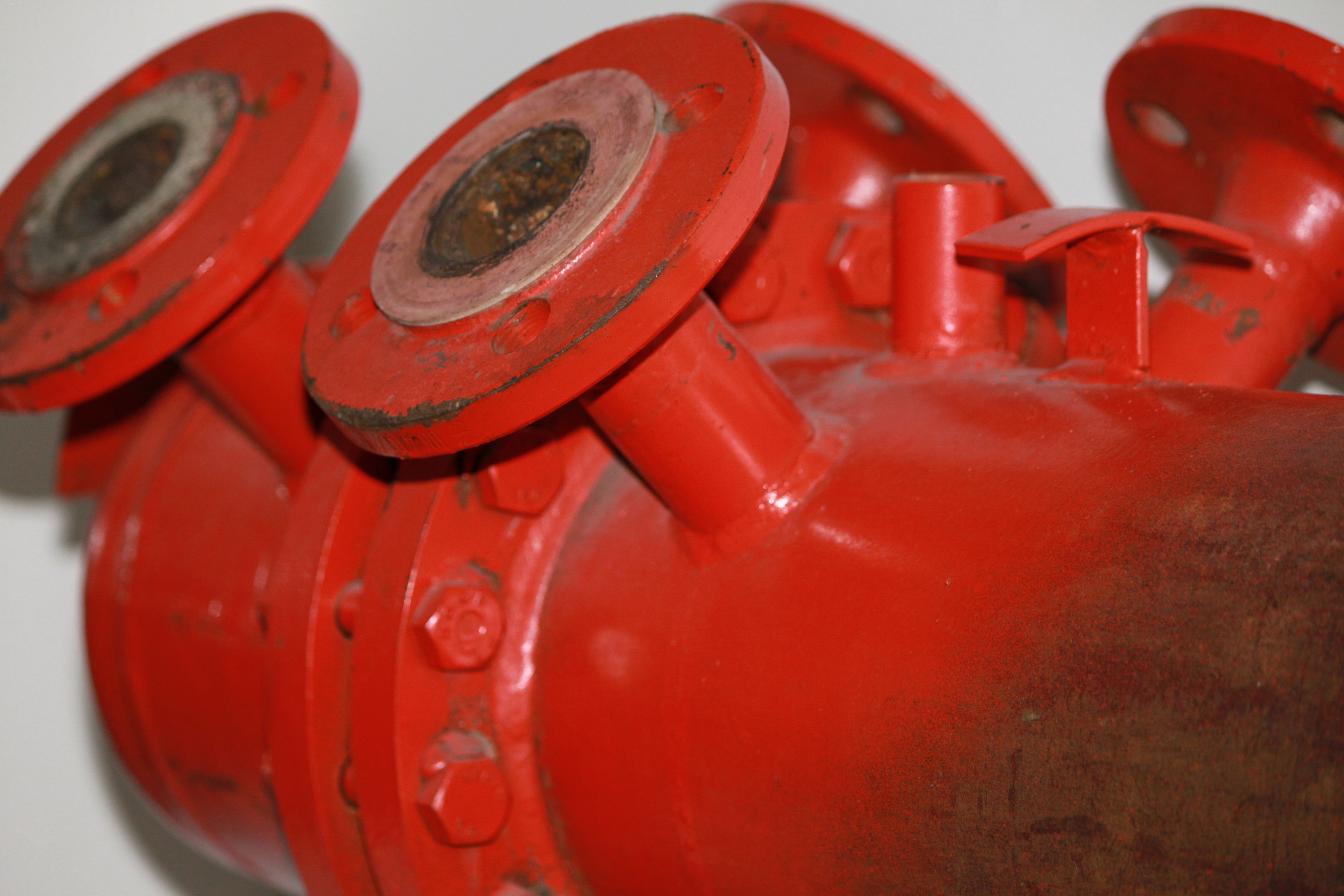 A close-up of a red fire hydrant with visible rust and wear.