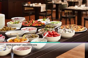 Un bufé de desayuno con diversos platos y pizza.