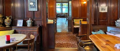 Un comedor tradicional con muebles de madera, una araña y vista al salón de comidas.