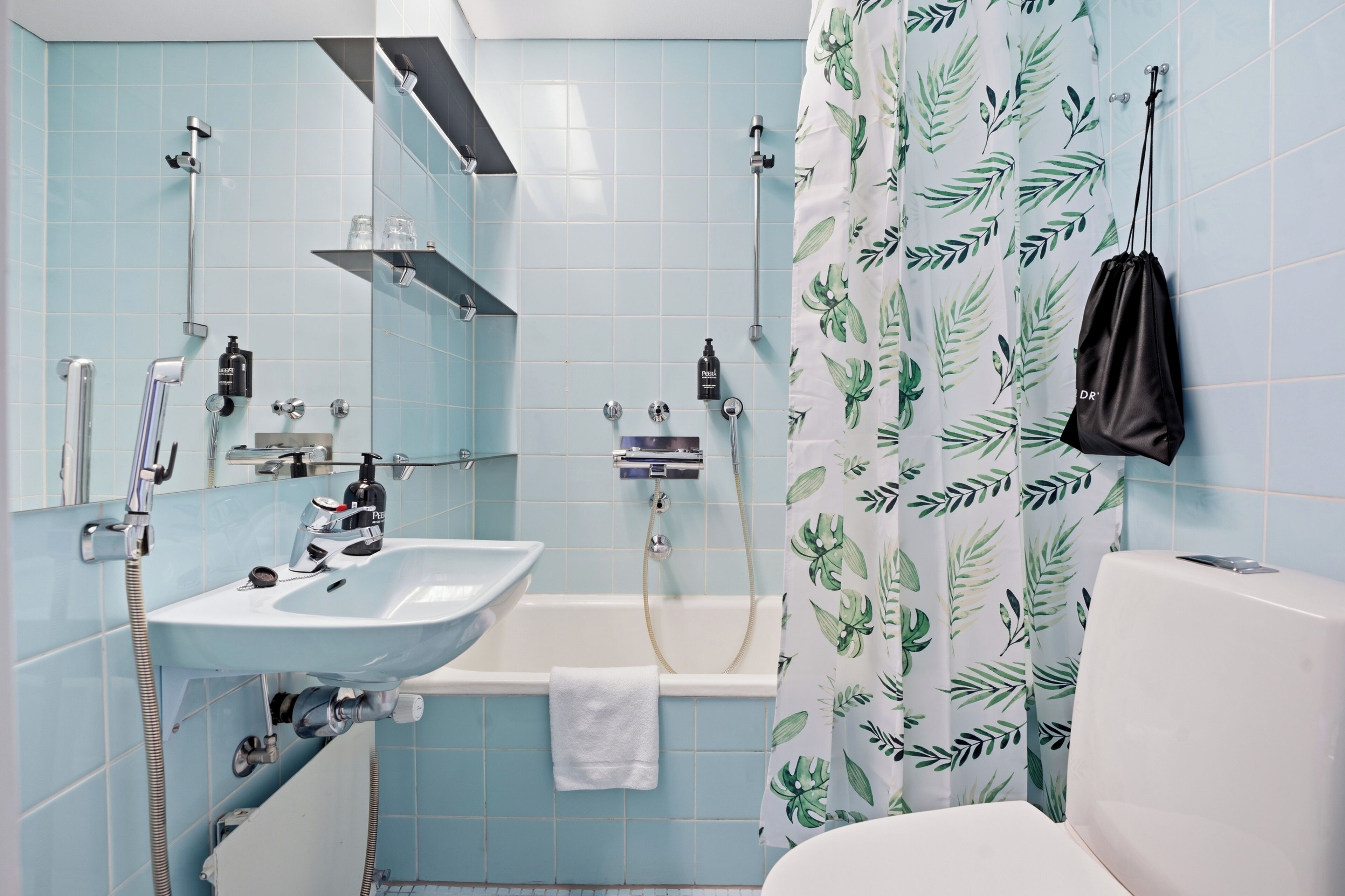 Un bagno con lavandino, specchio, doccia e WC.