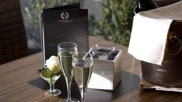A table with two champagne flutes, a menu, and a champagne bucket.