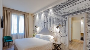 A hotel room with a large bed, a desk, a chair, and a mirror.
