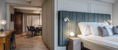 Une chambre d’hôtel moderne avec un grand lit, un petit bureau et un coin repas.