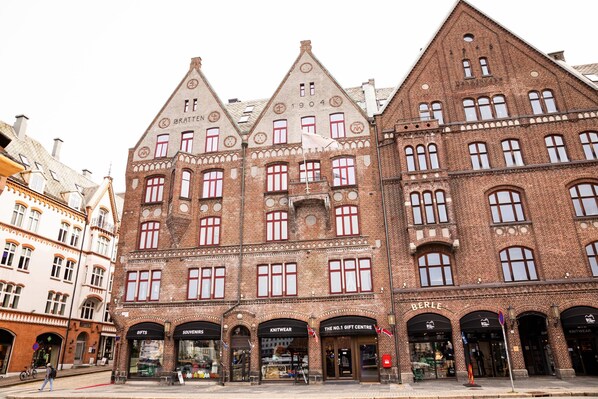 Un edificio histórico con varias fachadas comerciales, que incluye una tienda de ropa de punto y un centro de regalos.