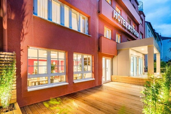 Un edificio rojo con un letrero que dice 'HOTEL ASTORIA'.