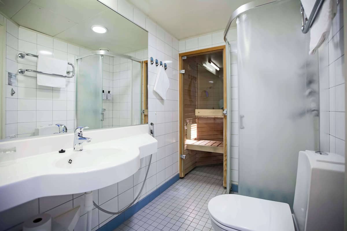 Ein modernes Badezimmer mit Waschbecken, Spiegel und Toilette in Weiß.