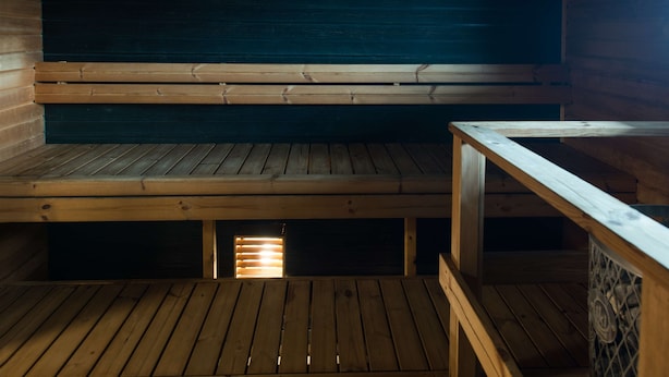 A wooden sauna with benches and a wooden floor.