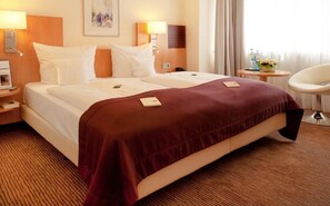 Relax in this inviting room with a large bed, bedside table, and comfortable chair.