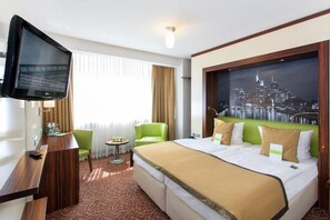 Relax in this stylish room with a large bed, flat-screen TV, and cityscape artwork.