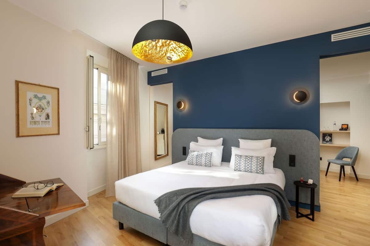 Une chambre moderne avec un grand lit, un bureau et une chaise.