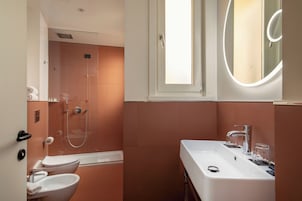 A modern bathroom with a shower, toilet, and sink.