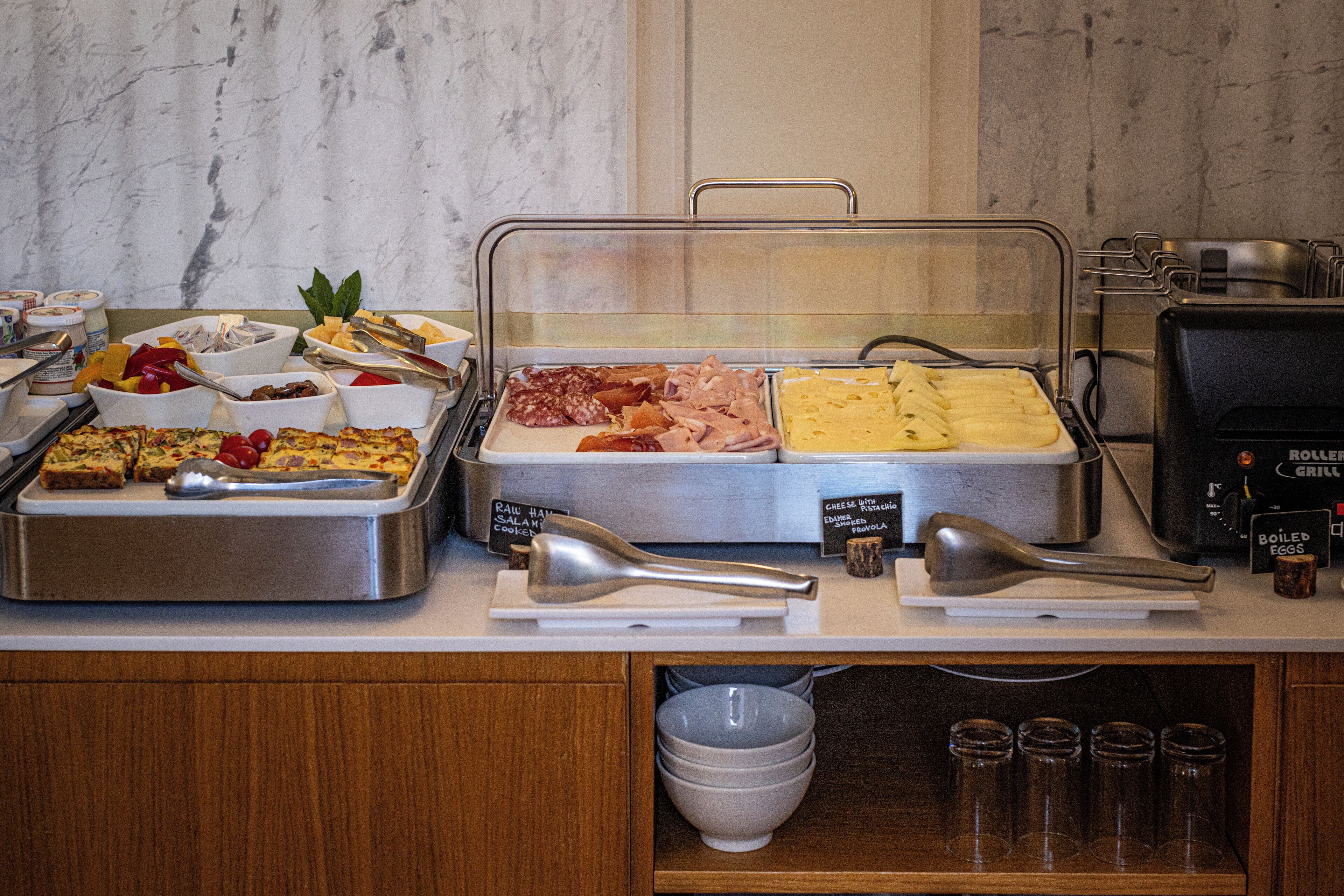 A buffet counter with various food items and condiments.