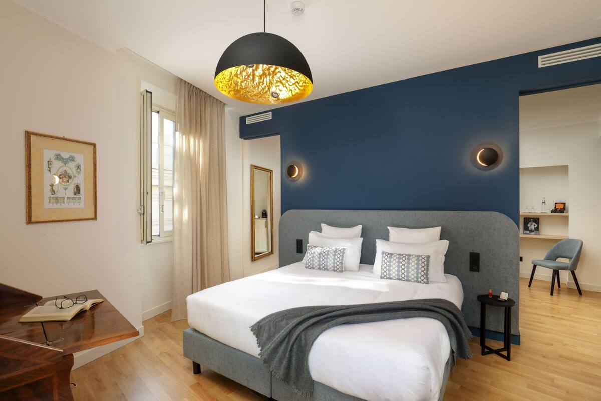 Une chambre moderne avec un grand lit, un bureau et une chaise.