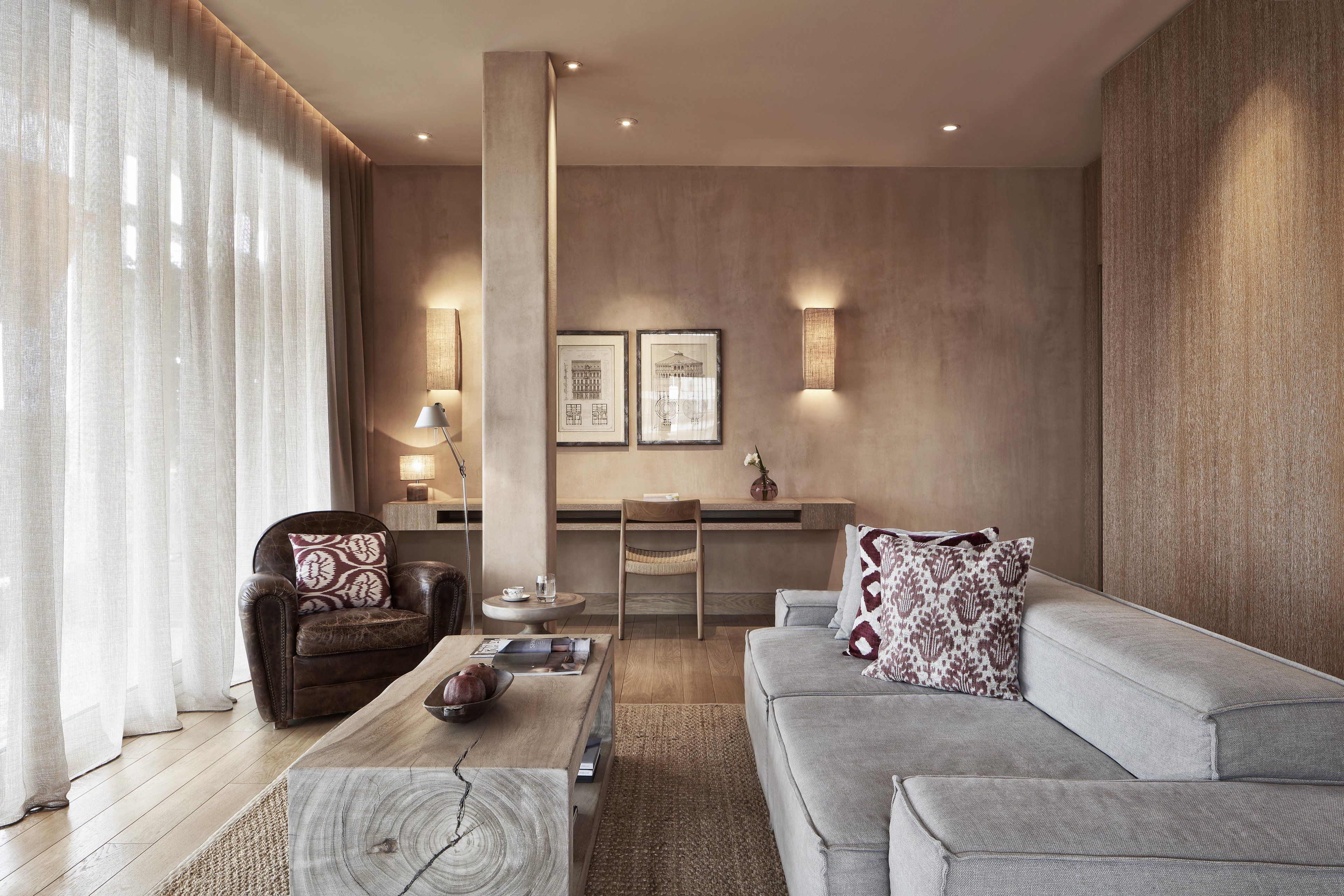 A modern living room with a sofa, armchair, coffee table, and a dining area with a chair and table.