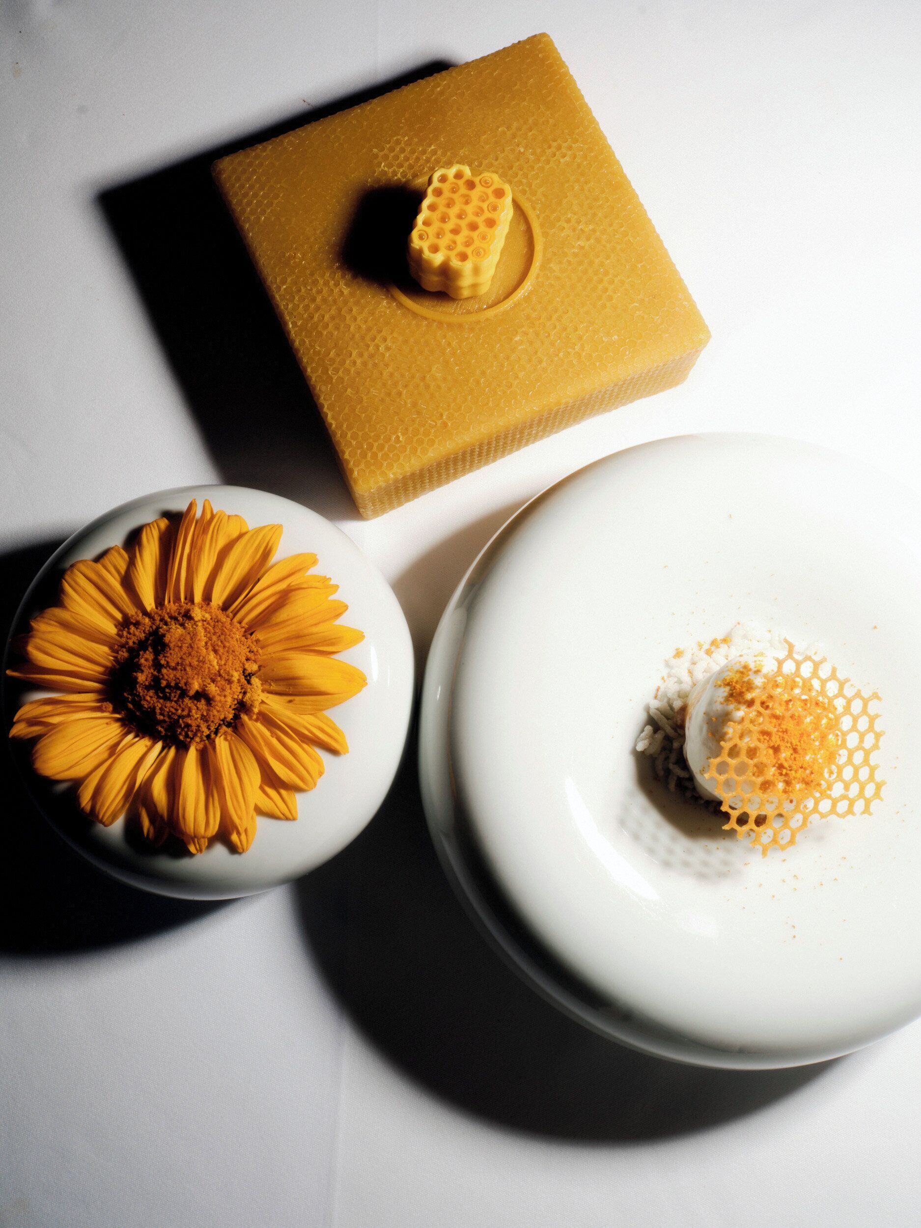 A white plate with a yellow flower and a white plate with a honeycomb pattern.