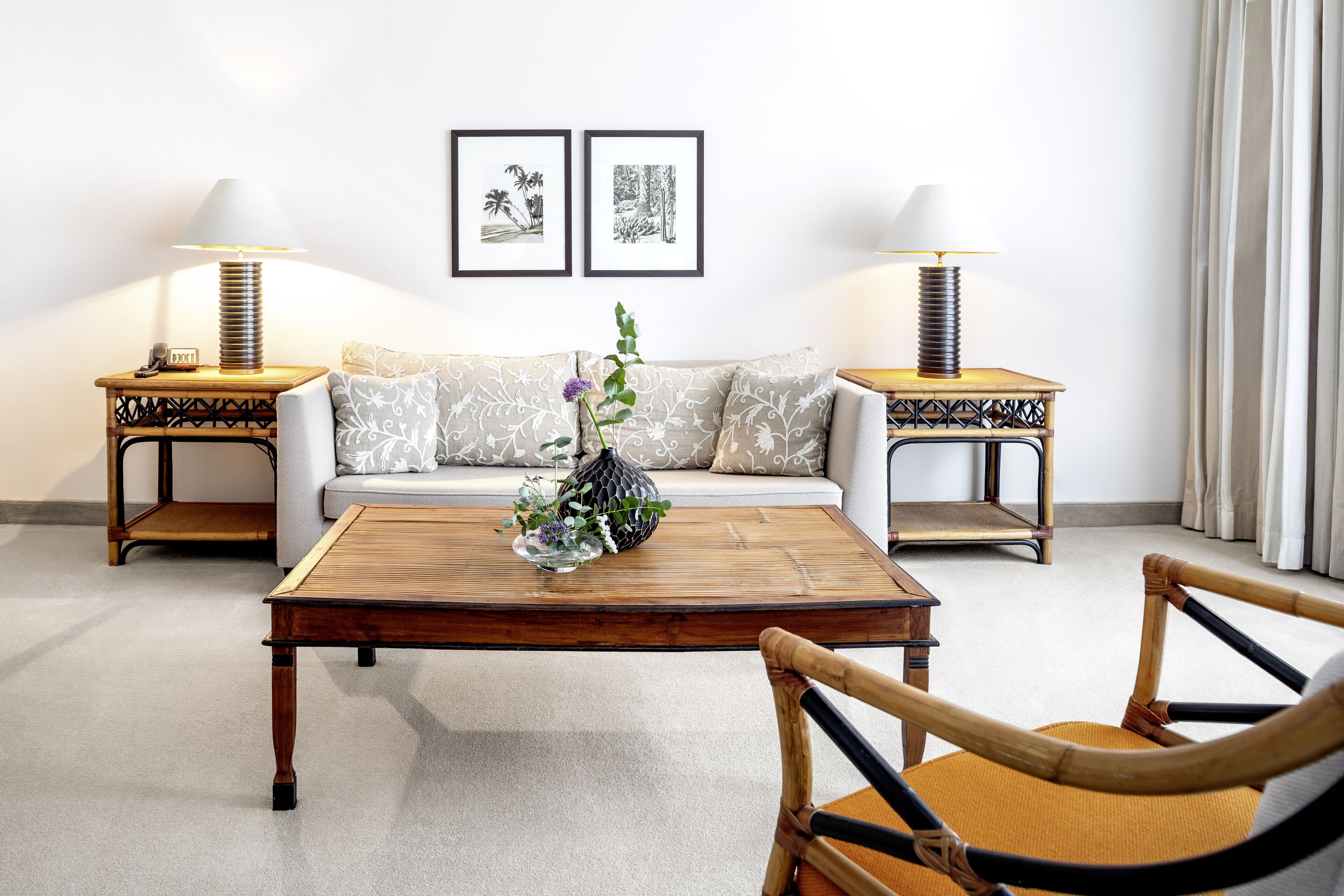 A living room with a sofa, two side tables with lamps, a wooden coffee table, and a chair.