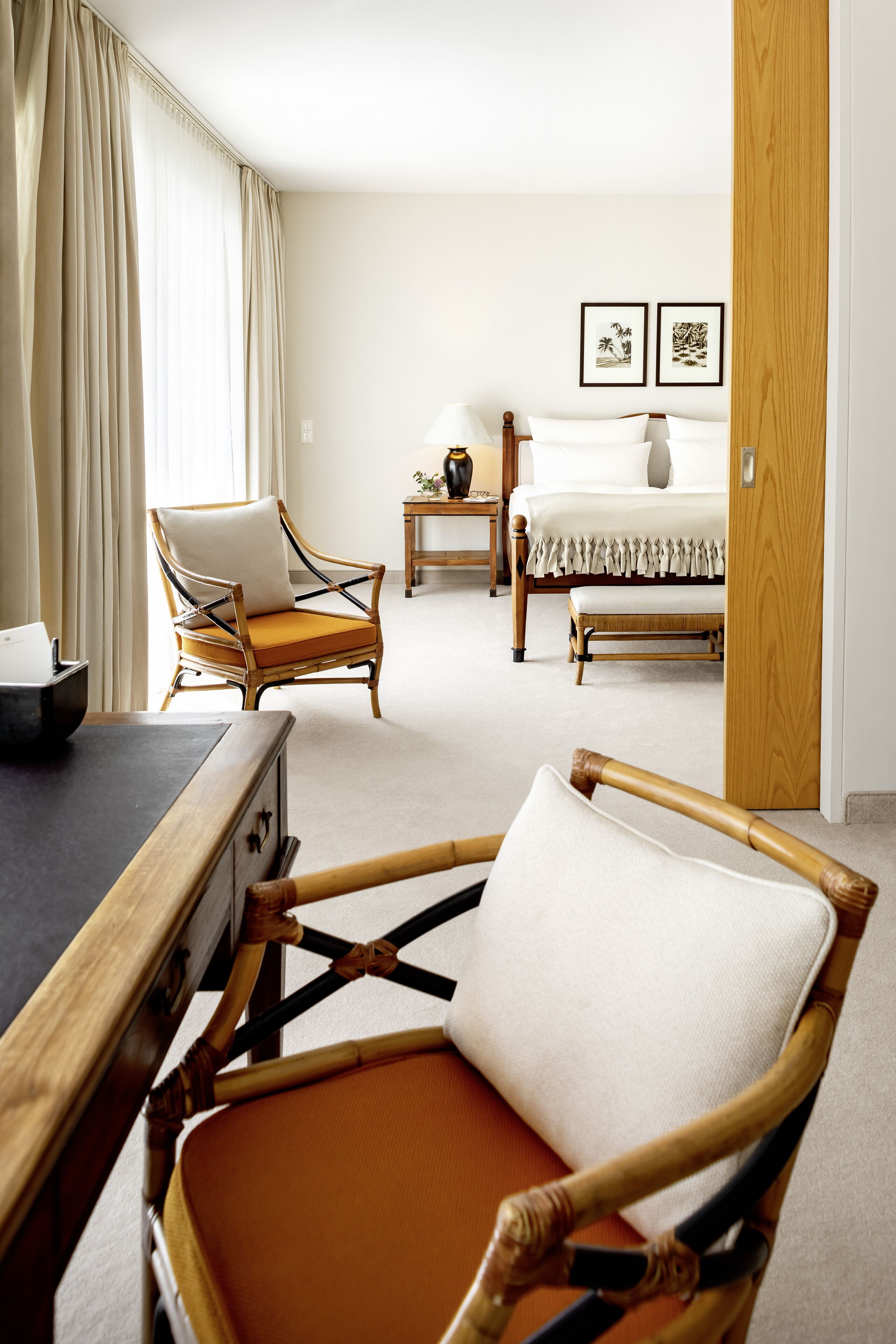 Une chambre d’hôtel avec un lit, une chaise, une table et une porte en bois.