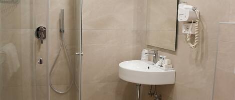 Ein modernes Badezimmer mit einer Duschkabine, einem Waschbecken und einer Toilette.