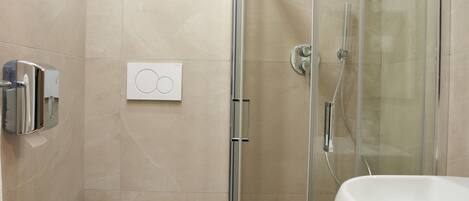 Un baño moderno con ducha acristalada, inodoro, bidé y lavabo.
