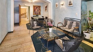 Una sala moderna con una mesa de centro de cristal, asientos cómodos y vistas al comedor.