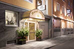 A hotel named "Hotel Alfa" with a classic facade, a welcoming entrance, and potted plants at the entrance. - Alfa City Centre (Munich)