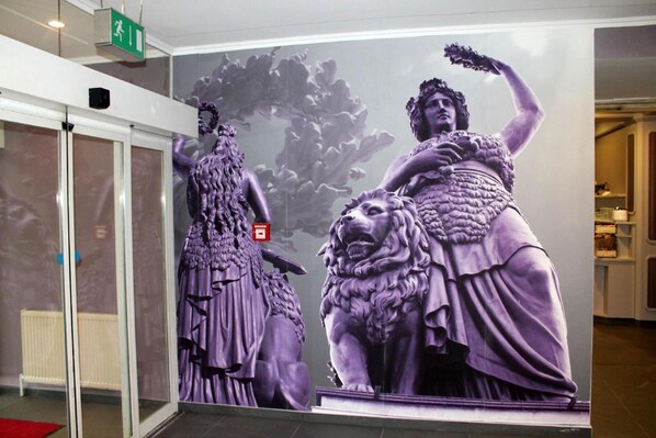 Un gran mural de una mujer y un león en un espacio público.