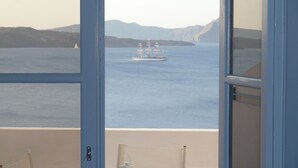 A view of a ship on the water from a balcony with a door frame visible in the foreground.