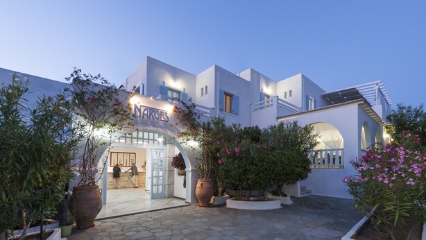 A modern building with a sign reading "NARGES" and a stone-paved courtyard with potted plants.