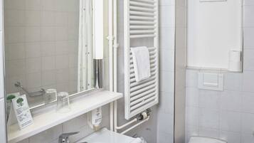 Ein Badezimmer mit Waschbecken, Spiegel, Toilette und Handtuchhalter.