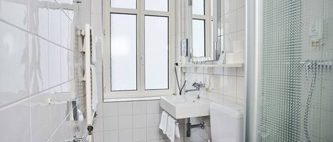 Un baño moderno con inodoro, lavamanos y ventana.