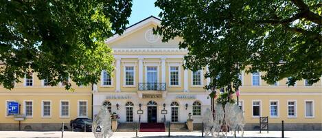 A building with a sign reading "RESTAURANT KURHAUS SPIELBANK" and a fountain in front.